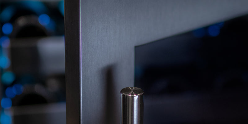 An elegant black-glass wine fridge door with a towel bar handle