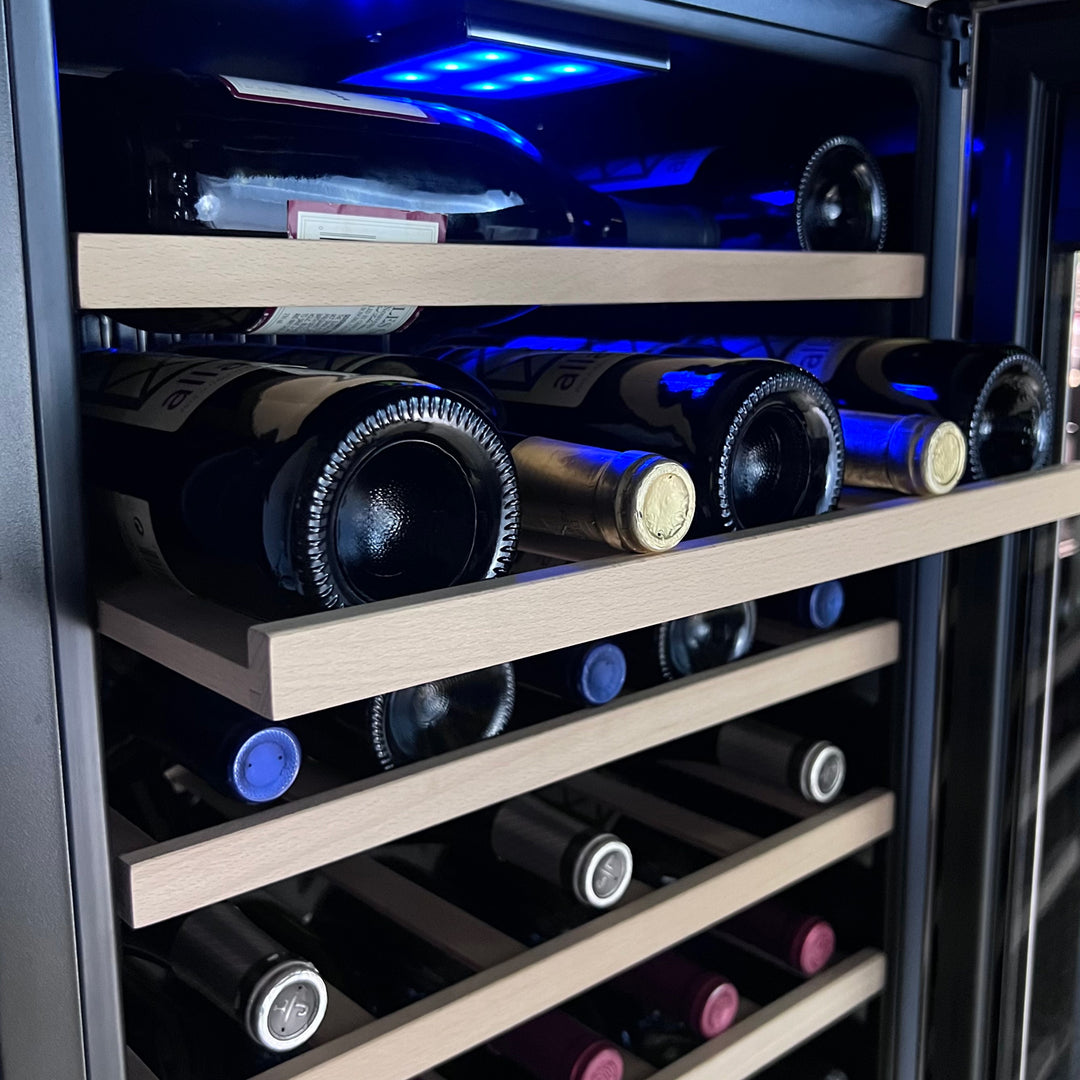 Wine bottles bathed in cool blue light within a wine refrigerator