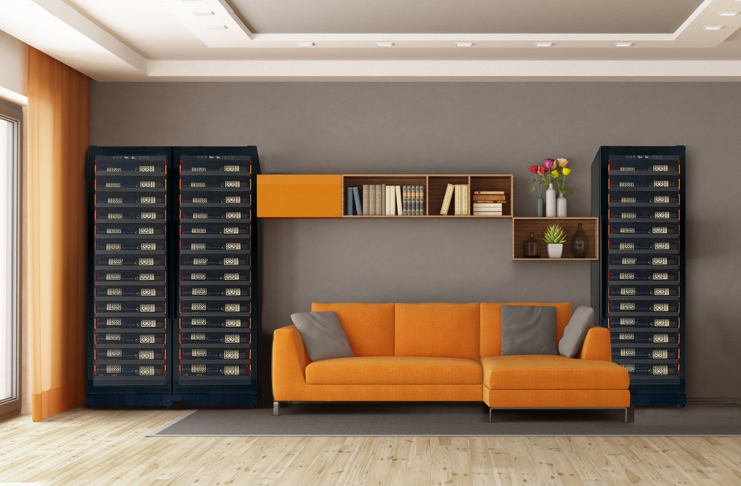 Monolithic black standing wine refrigerators flank a cozy orange sofa