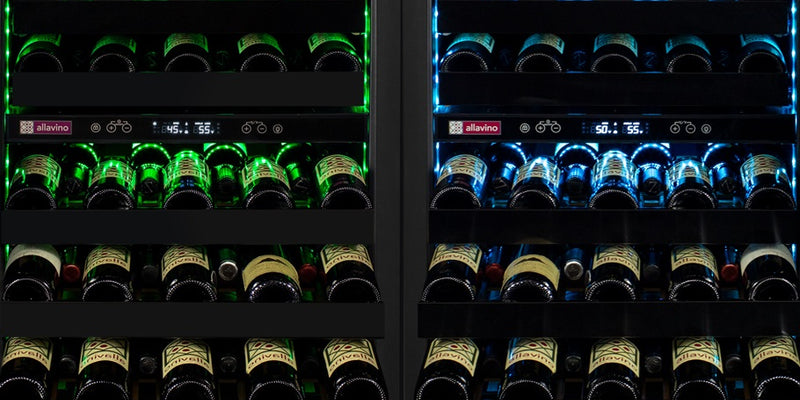 Two colors of vibrant LED light reflect off of dark glass wine bottles